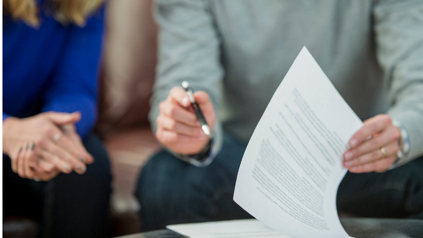 Un homme et une femme signent ensemble une offre de protection juridique. Afin de trouver le bon produit, ils ont scrupuleusement comparé les assurances.